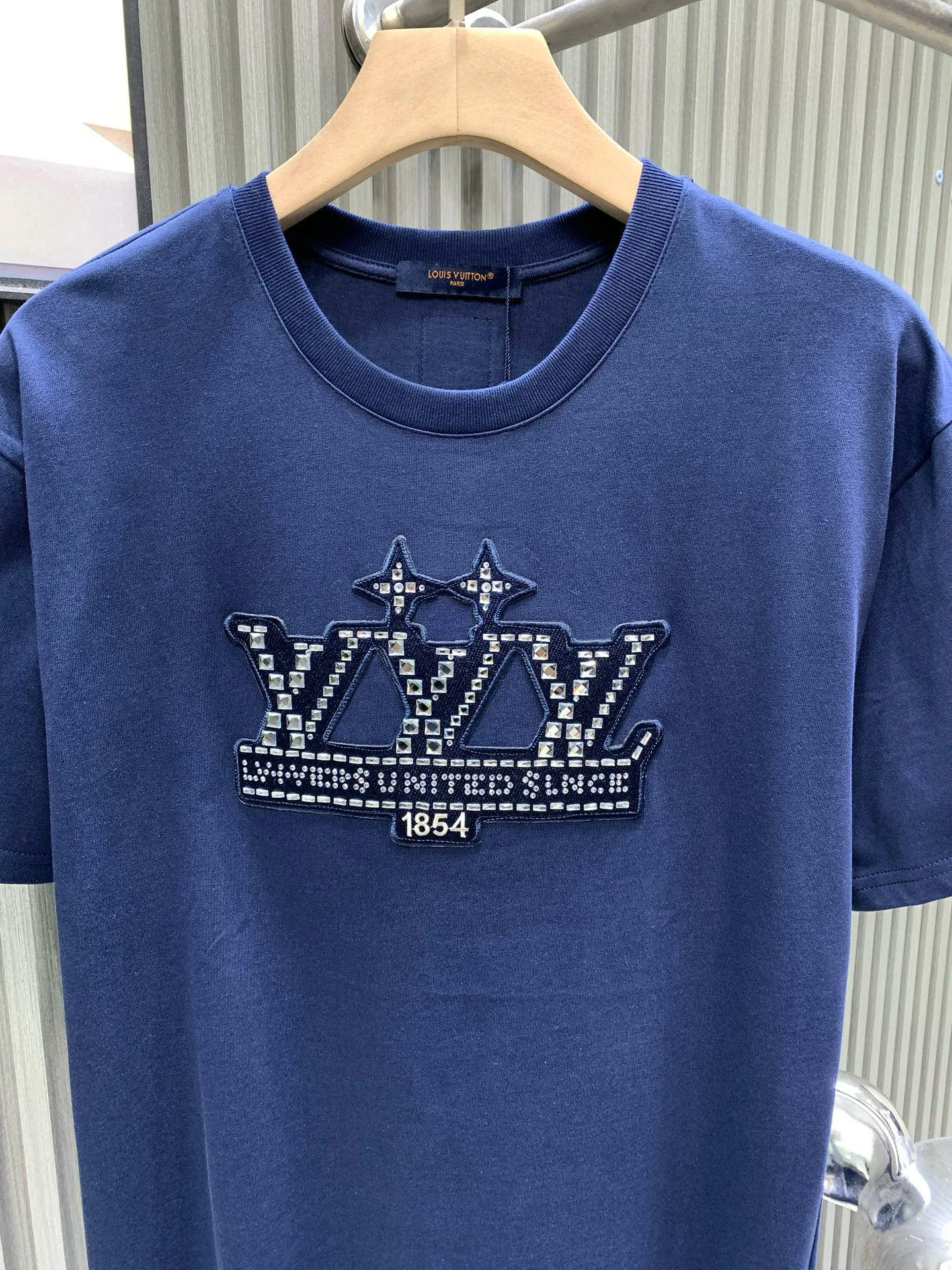 🅿️240 🀄️ Louis Vuitton 1V 2025 new style 1854 diamond letter cotton short sleeves 32-count fine cotton plain fabric is made of combed cotton after a special process. Its fibers are more slender and neat. Therefore, the texture and durability of the fabric are significantly improved. The pure cotton material has excellent moisture absorption. The plain fabric is soft to the touch and comfortable to wear. The fiber structure of combed cotton is tighter. Therefore, the fabric made has better wear resistance and is not easy to pill or deform. The flowers are positioned and embellished with patterns. Diamond selection is to choose diamonds suitable for hot drilling. Diamond arrangement is to arrange the diamonds on the template according to the designed pattern. The diamonds are fixed on the fabric through a hot drilling machine. The color of the back glue should be uniform and consistent, and the firmness should be high. It combines the softness of silicone oil and the high-density characteristics of elastic glue. The material has excellent stretching and recovery properties and can quickly return to its original shape when subjected to external forces to maintain the integrity and clarity of the pattern.
